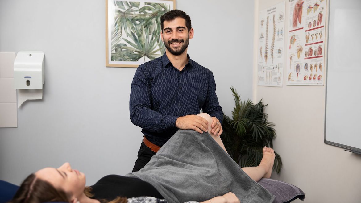 Sydney Osteopath Dr Evan Marnezos assessing a hip and knee